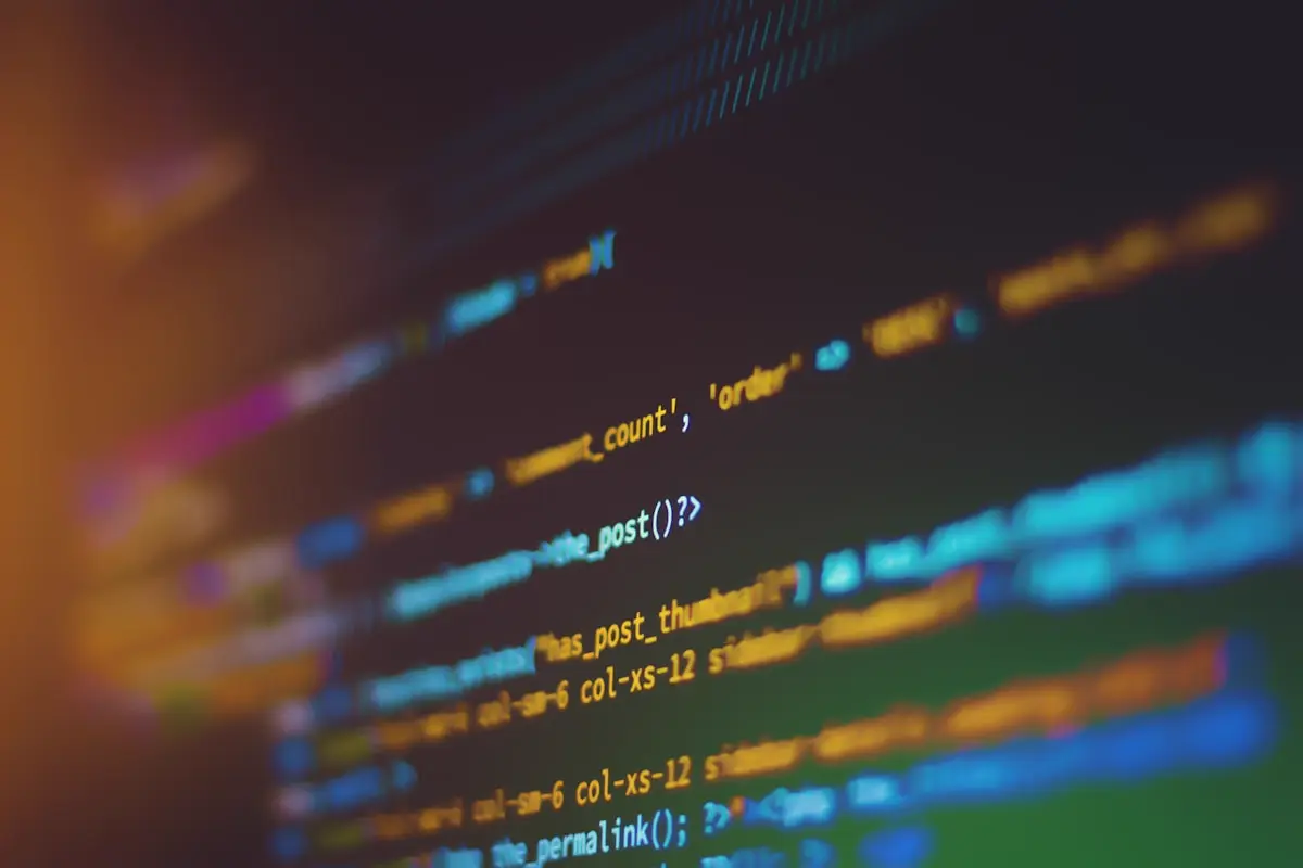 A laptop screen glowing in the dark with lines of code; somewhere in that codebase is a nested loop waiting to ruin your week